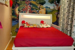 ein Schlafzimmer mit einem roten Bett mit einem Disney-Wandbild in der Unterkunft Beautiful centrally located spacious Penthouse flat. in London