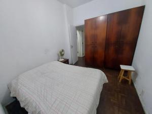 1 dormitorio con 1 cama y armario de madera en In Copacabana Quadra da Praia 3 quartos lindos, en Río de Janeiro