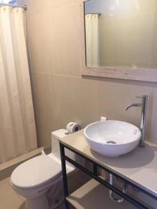 a bathroom with a sink and a toilet and a mirror at HOTEL AEROPUERTO Cusco in Cusco