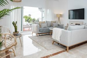 ein Wohnzimmer mit 2 Sofas und einem TV in der Unterkunft PA18- El Paraiso Estepona by Roomservices in Estepona