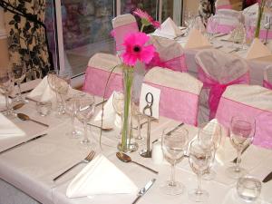 un tavolo con un vaso con un fiore rosa di Deebert House Hotel a Kilmallock