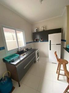 a kitchen with a sink and a refrigerator at Casa em Mongaguá 900mts da praia in Mongaguá