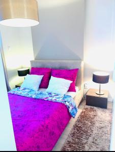 a bedroom with a bed with a pink blanket at City Centre Platinum Towers Apartment in Warsaw