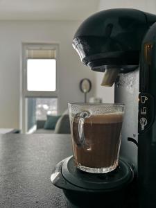 uma chávena de café sentada em cima de uma máquina de café expresso em Apartament dla Ciebie em Lańcut