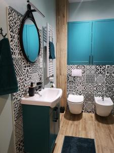 uma casa de banho com um lavatório, um espelho e um WC. em Apartament dla Ciebie em Lańcut