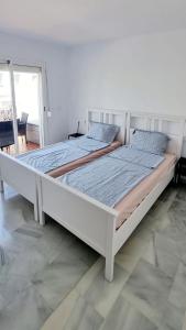 1 cama blanca grande en una habitación blanca en Mijas Holiday, en Fuengirola