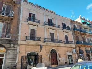 - un grand bâtiment en briques avec des balcons dans une rue dans l'établissement Quintino Sella 175 Foresteria Matisse, à Bari