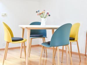 four chairs around a table with a vase of flowers at Ferienwohnung am Sattelhof #2 in Türnitz