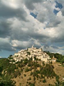 ein Dorf auf einem Hügel unter einem wolkigen Himmel in der Unterkunft Albergo Diffuso Crispolti in Labro