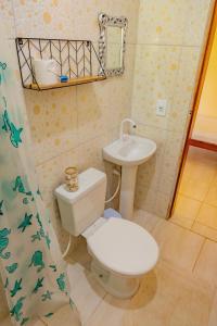 a small bathroom with a toilet and a sink at Suítes da Barra in Ubatuba