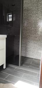 a bathroom with a shower with a tiled floor at Bij BRAKKE in Paramaribo