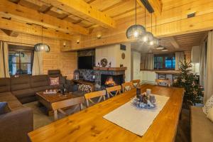 a living room with a table and a fireplace at Drevenica Lesanka in Demanovska Dolina