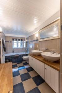 ein Badezimmer mit zwei Waschbecken und einem karierten Boden in der Unterkunft Ferienhaus Strandgut in Oevenum