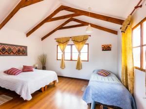 Habitación con 2 camas, suelo de madera y ventanas. en La Chakana Lodge, en Putre
