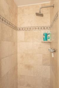a bathroom with a shower with a shower head at Hawaii Oceanfront Beach House Paradise on the Beach Family Activities in Haleiwa
