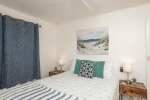 ハレイワにあるHawaii Oceanfront Beach House Paradise on the Beach Family Activitiesのベッドルーム1室(ベッド1台付)が備わります。壁には絵画が飾られています。