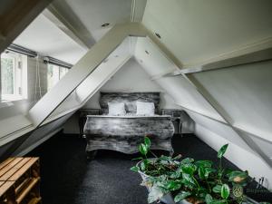 a attic room with a bed and some plants at de Zeelberg in Valkenswaard