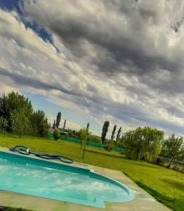 una piscina en un campo con un cielo nublado en Casa Câmeron del Mar en San Rafael
