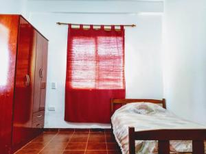 a bedroom with a red curtain and a bed at Signos de Merlo in Merlo +9 photos