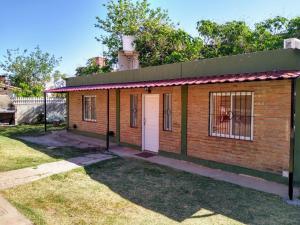 una pequeña casa de ladrillo con una puerta blanca en Signos de Merlo en Merlo