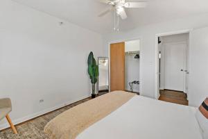 een witte slaapkamer met een bed en een plafondventilator bij 1BR Picturesque Apt with Modern Amenities - Salem 8C in Arlington Heights