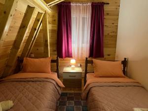 2 Betten in einem Zimmer mit Fenster in der Unterkunft LAF Guest House in Kolašin