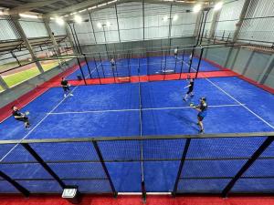 a group of people playing tennis on a tennis court at Olinda Hotel e Eventos in Toledo