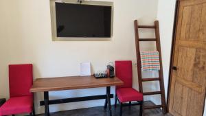 a room with a table and chairs and a television at Casa de la Ballena in Sayulita