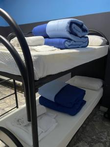 ein Etagenbett mit blauen und weißen Handtüchern darauf in der Unterkunft Alexander hostel in Neapel
