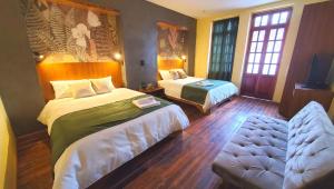 Habitación de hotel con 2 camas y sofá en Hotel Inti Quito, en Quito
