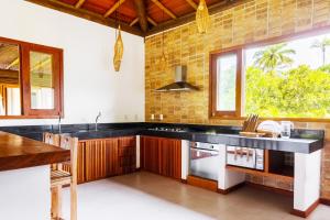 cocina con encimera negra y ventana en Paraiso do Dende - Barra Grande - Beira Mar, en Barra Grande