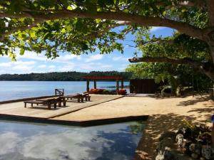 a picnic table and a gazebo next to the water at Mystic Sands in Utungake