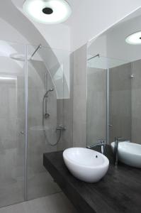 La salle de bains est pourvue d'un lavabo blanc et d'une douche. dans l'établissement Galeria River, à Ljubljana