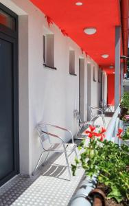 a row of chairs and flowers on a building at 2 REST 