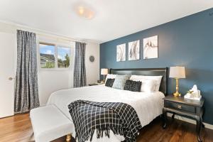 ボイジーにあるSunset Ave Lux! 4BR Large Home in Downtown Boiseの青い壁のベッドルーム1室、ベッド1台、椅子1脚が備わります。