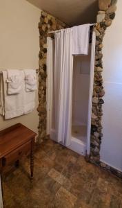 a bathroom with a shower with a white shower curtain at Hikers Cimarron Inn & RV Park in Cimarron