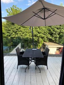 une table et des chaises avec un parasol sur une terrasse dans l'établissement Appartement met groot terras, à Mortsel