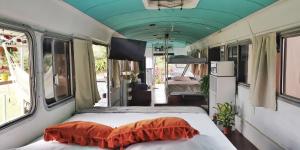 um vagão de comboio com duas camas e uma televisão de ecrã plano em Dreamcatcher House Bus Experience 2 em Sarchí
