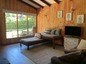 a living room with a couch and a flat screen tv at Cabañas Koyam Ruka in Licán Ray