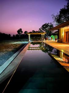 una casa con piscina por la noche en Villa BAOBAB, 