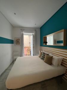 um quarto com uma cama grande e uma parede azul em Iberflat Fabiola em Sevilha