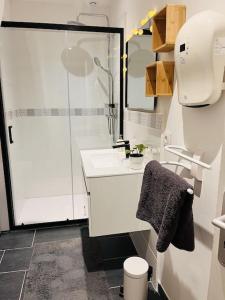 une salle de bain blanche avec une douche et un lavabo dans l'établissement Superbe maison plein centre, à Merville 38 autres photos