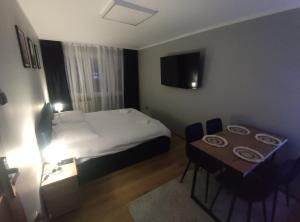 een hotelkamer met een bed en een tafel bij Apartament Hetmański in Wałcz