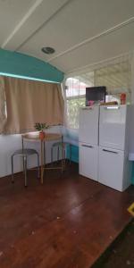 Habitación con escritorio, mesa y TV. en Combi Bus Dreamcatcher, en Sarchí