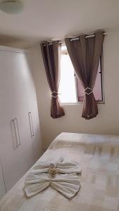 a bedroom with a bed with a bow on it at Apartamento aconchegante Parnamirim Natal in Parnamirim