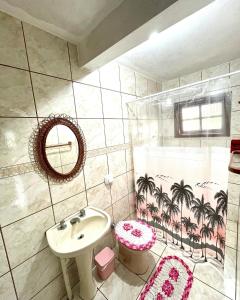 a bathroom with a sink and a toilet and a mirror at Pousada Happy in São Francisco do Sul