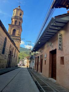 eine leere Straße mit einem Uhrturm und einem Gebäude in der Unterkunft HOTEL BOUTIQUE EL CAMPANARIO in San Gil