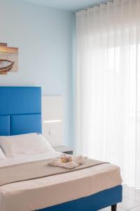a bed with a blue headboard in a bedroom at Hotel Continental in Tortoreto Lido