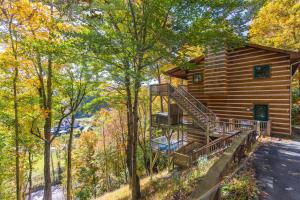 eine Blockhütte im Wald mit einer Treppe in der Unterkunft Log Inn at River Ridge in Boone