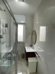 a white bathroom with a sink and a mirror at Appartamento confortevole M.I. Casa in Cusano Milanino